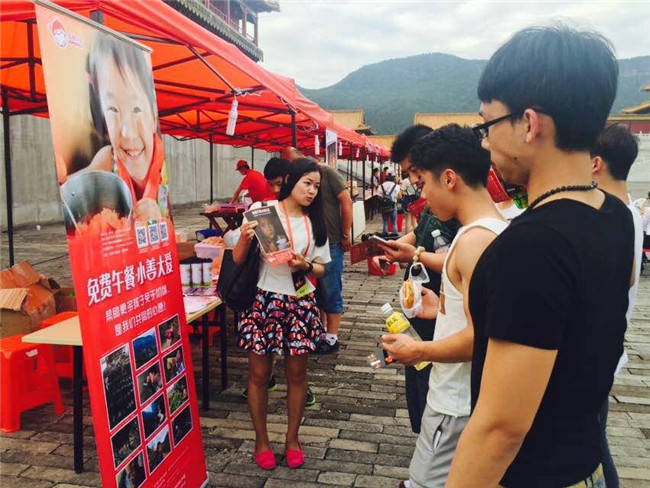 义卖区志愿者正在向球迷粉丝介绍免费午餐.jpg